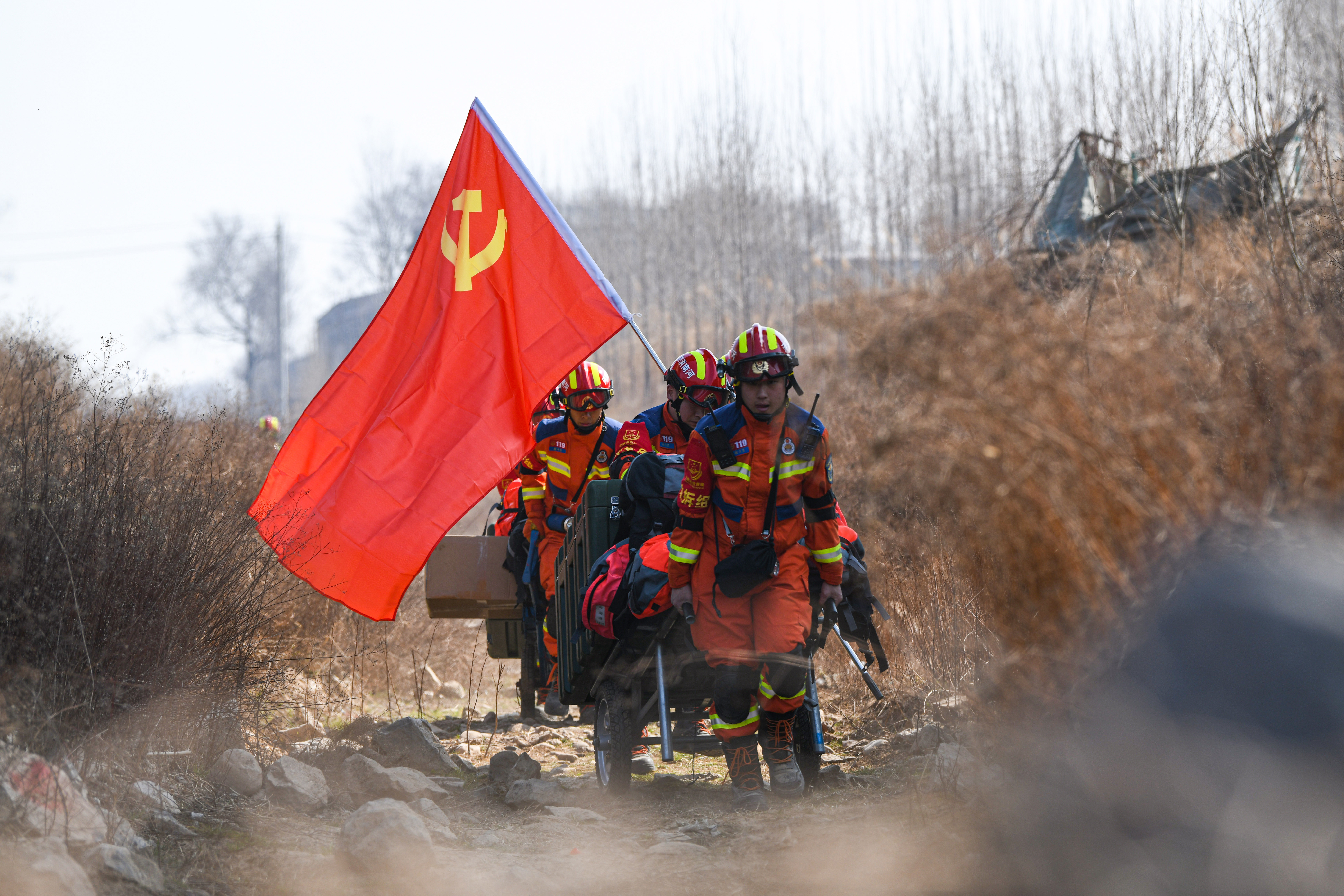 参加“守护中原·2024”地震灾害救援跨区域实战拉动演练的消防救援人员高擎红旗。.jpg