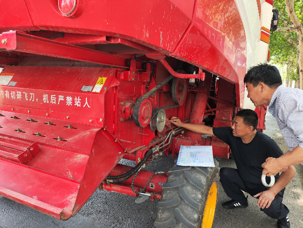 5月20日，河南郏县，农机人员正在对联合收割机进行审检。(杜冠甲 摄).png